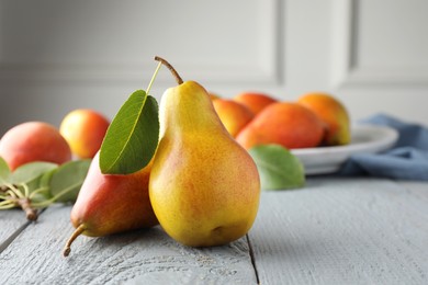 Photo of Ripe juicy pears on grey wooden table, selective focus