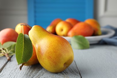 Photo of Ripe juicy pears on grey wooden table, selective focus