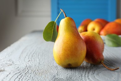 Photo of Ripe juicy pears on grey wooden table, selective focus