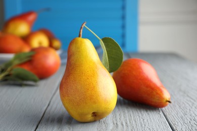 Photo of Ripe juicy pears on grey wooden table, selective focus