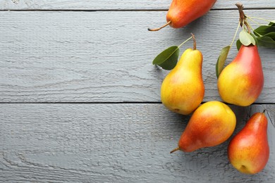 Photo of Ripe juicy pears on grey wooden table, flat lay. Space for text