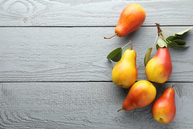 Photo of Ripe juicy pears on grey wooden table, flat lay. Space for text