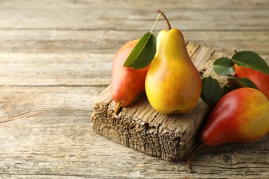 Photo of Ripe juicy pears on wooden table, space for text