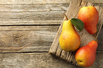 Photo of Ripe juicy pears on wooden table, top view. Space for text