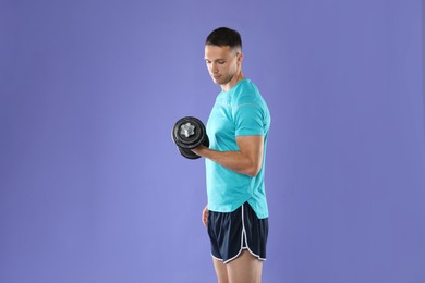 Photo of Man exercising with barbell on violet background