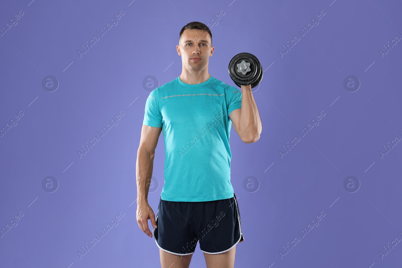 Photo of Man exercising with barbell on violet background