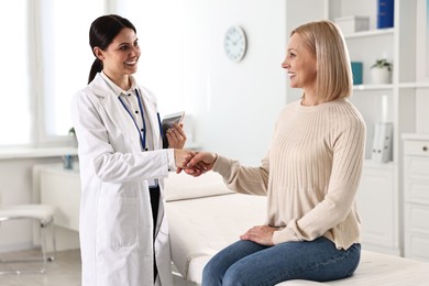 Photo of Doctor and patient shaking hands in clinic