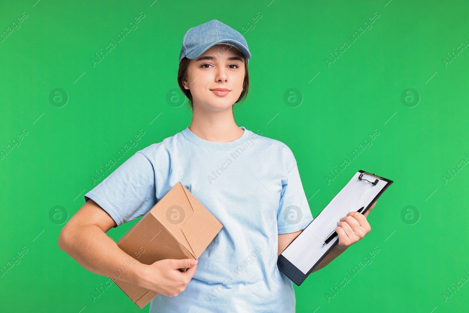 Photo of Girl in uniform with parcel and clipboard on green background. Work for teenagers