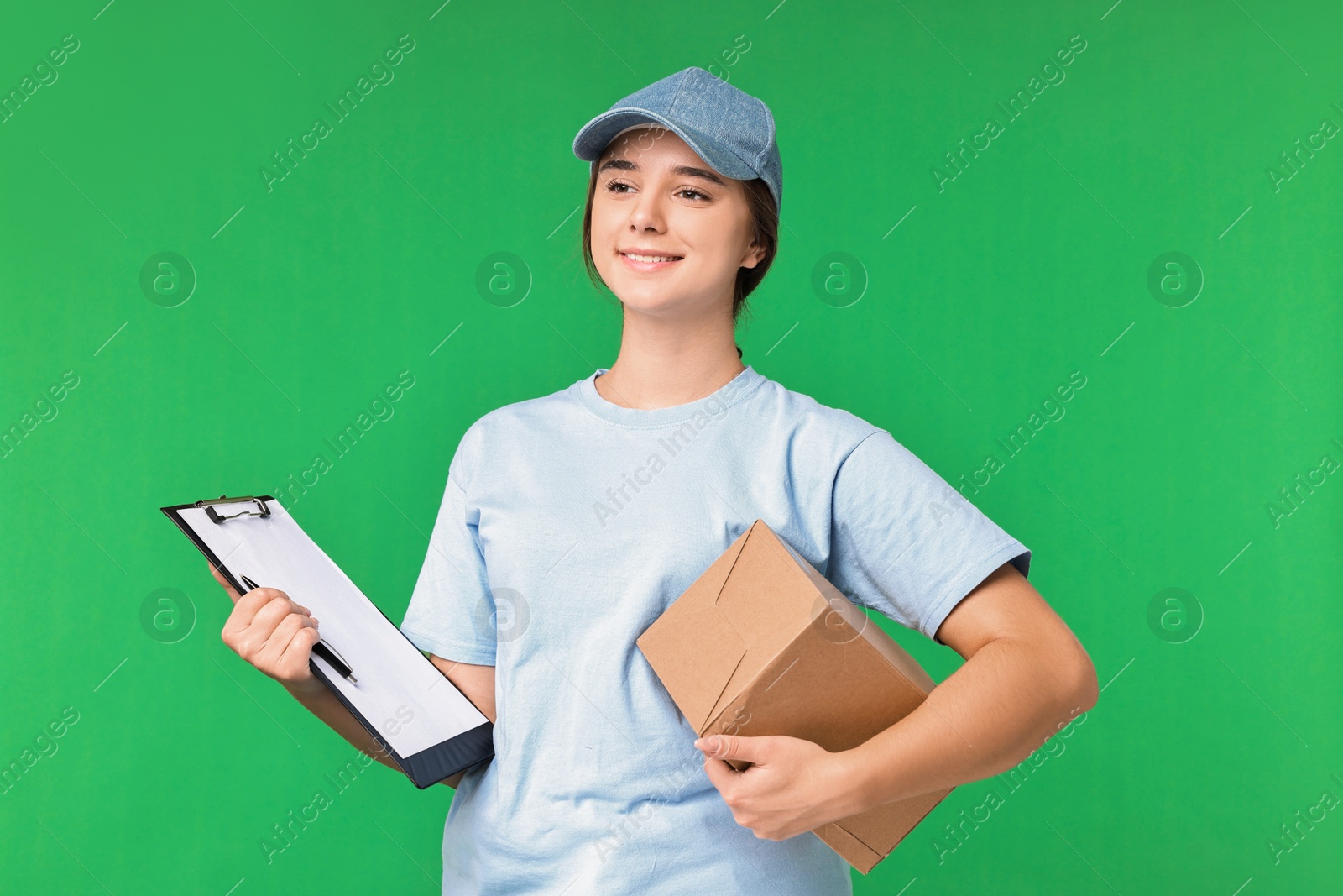 Photo of Girl in uniform with parcel and clipboard on green background. Work for teenagers