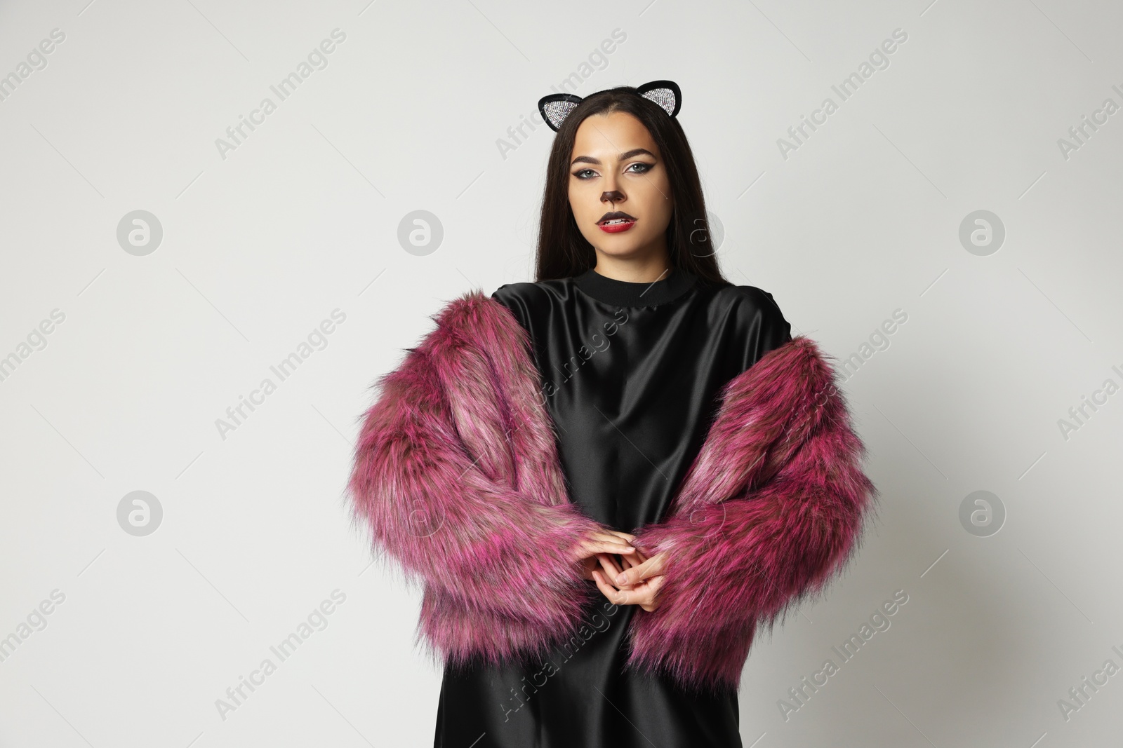 Photo of Attractive woman with cat makeup and ears on white background