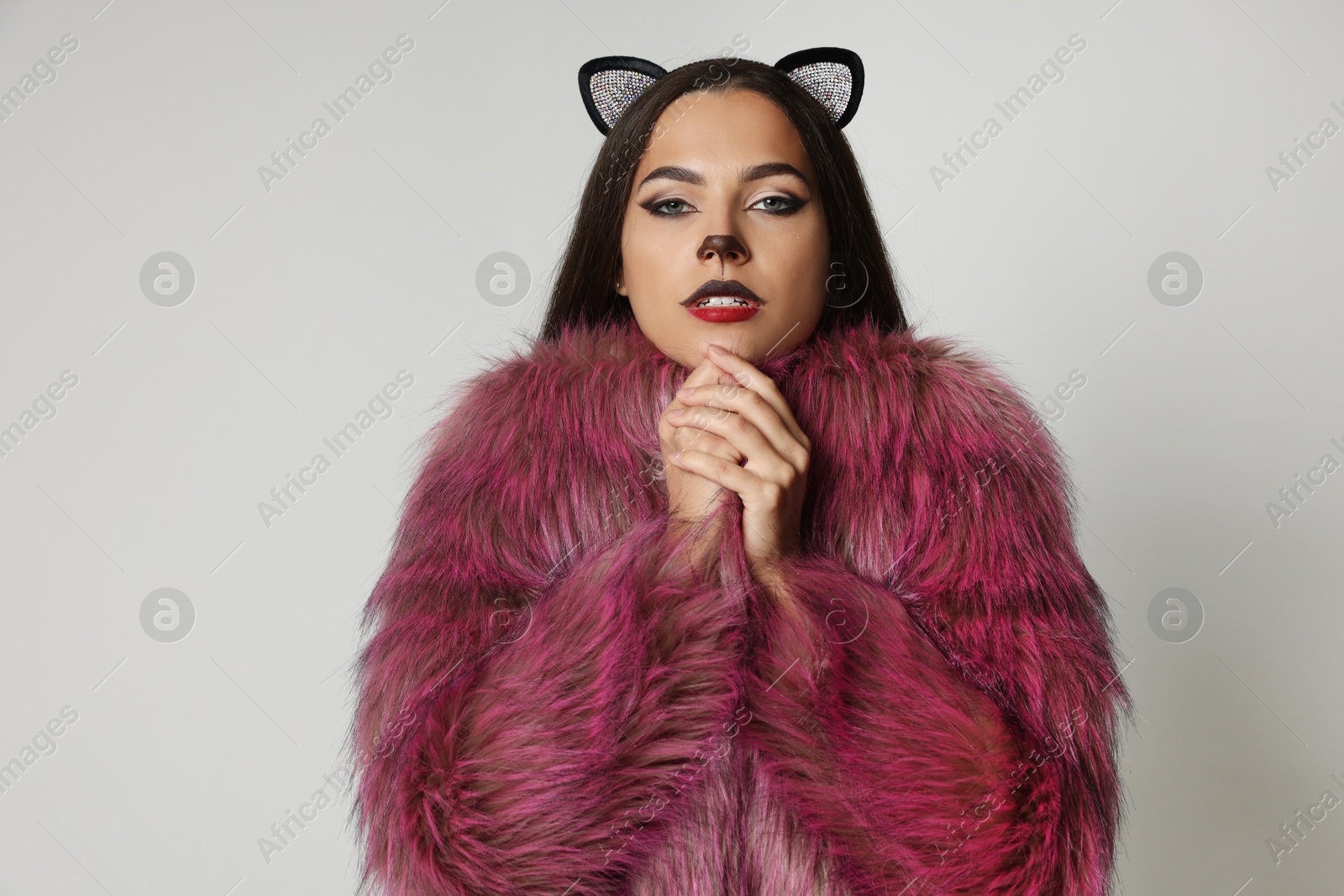 Photo of Attractive woman with cat makeup and ears on white background