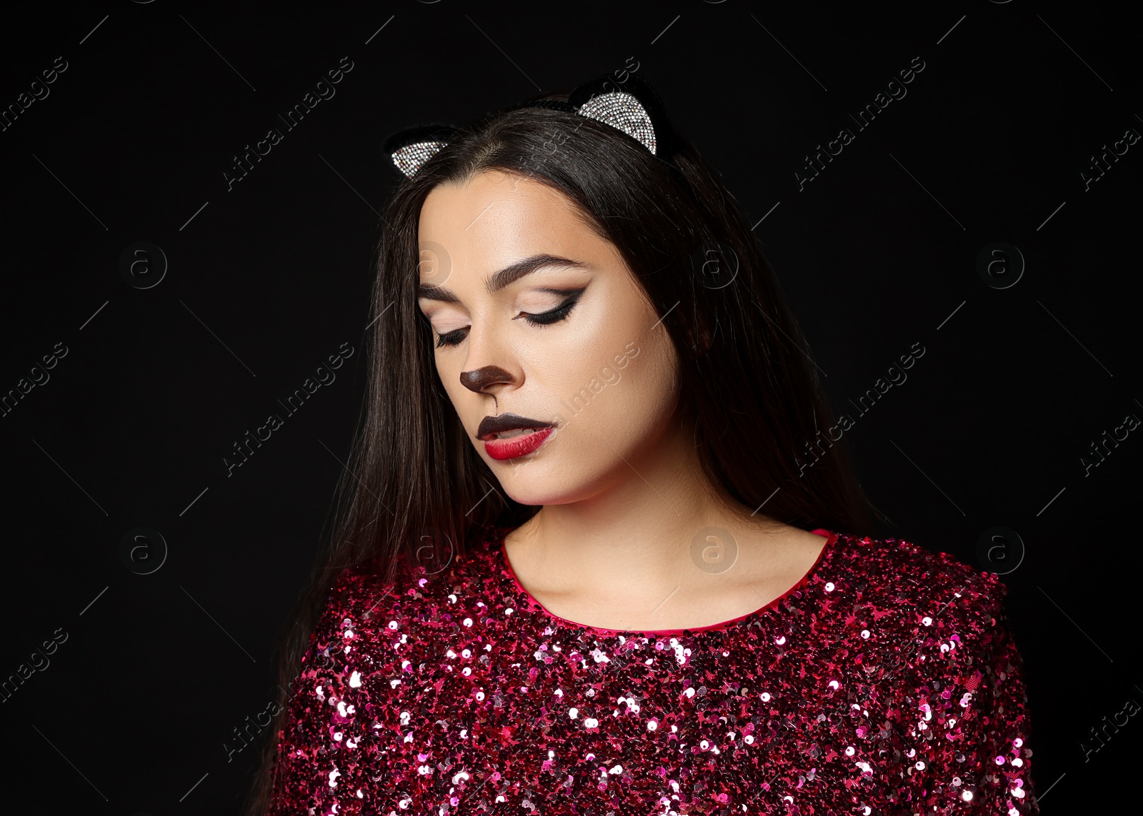 Photo of Charming woman with cat makeup and ears on black background