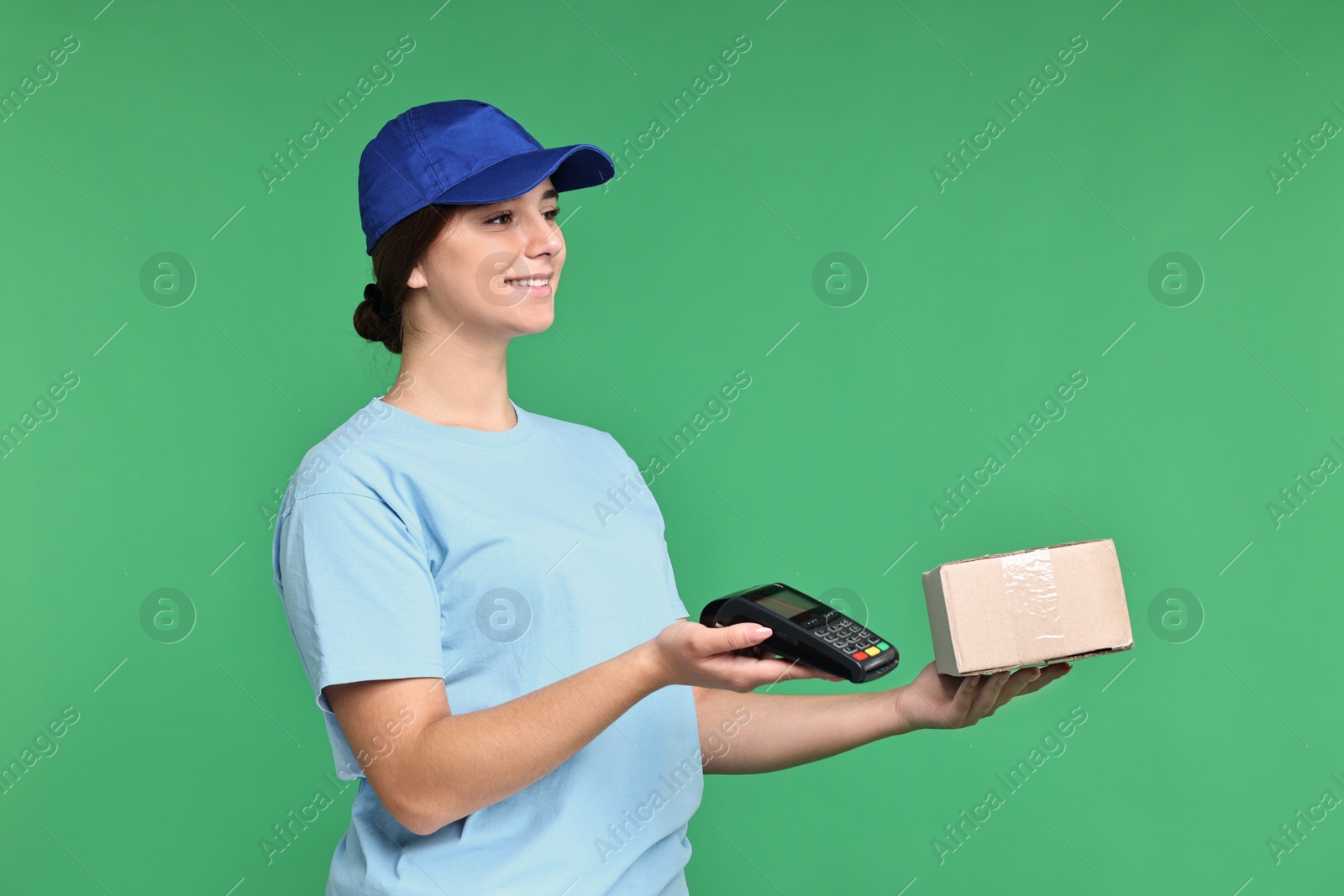 Photo of Girl in uniform with parcel and payment terminal on green background. Work for teenagers