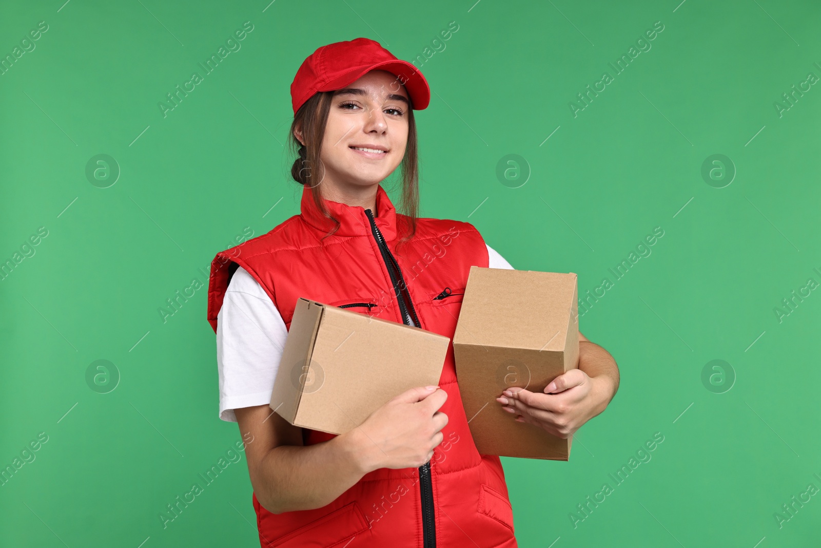 Photo of Girl in uniform with parcels on green background. Work for teenagers