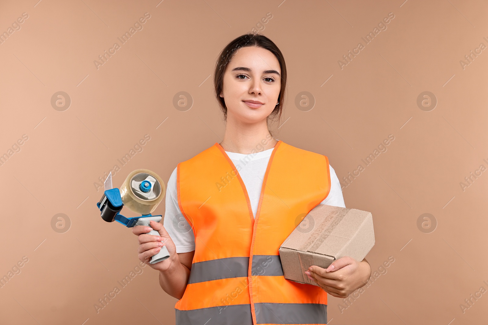 Photo of Girl in uniform with adhesive tape and parcel on pale brown background. Work for teenagers