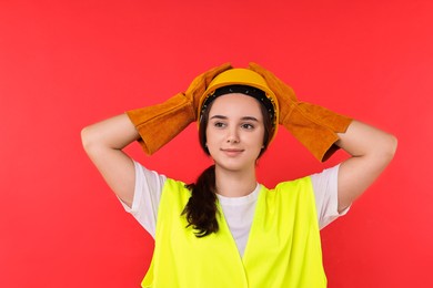 Photo of Girl with safety equipment on red background. Work for teenagers