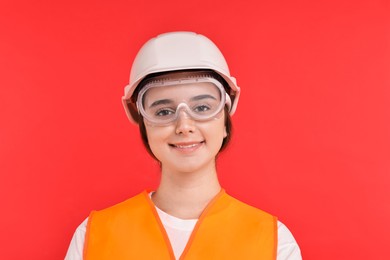 Photo of Girl with safety equipment on red background. Work for teenagers