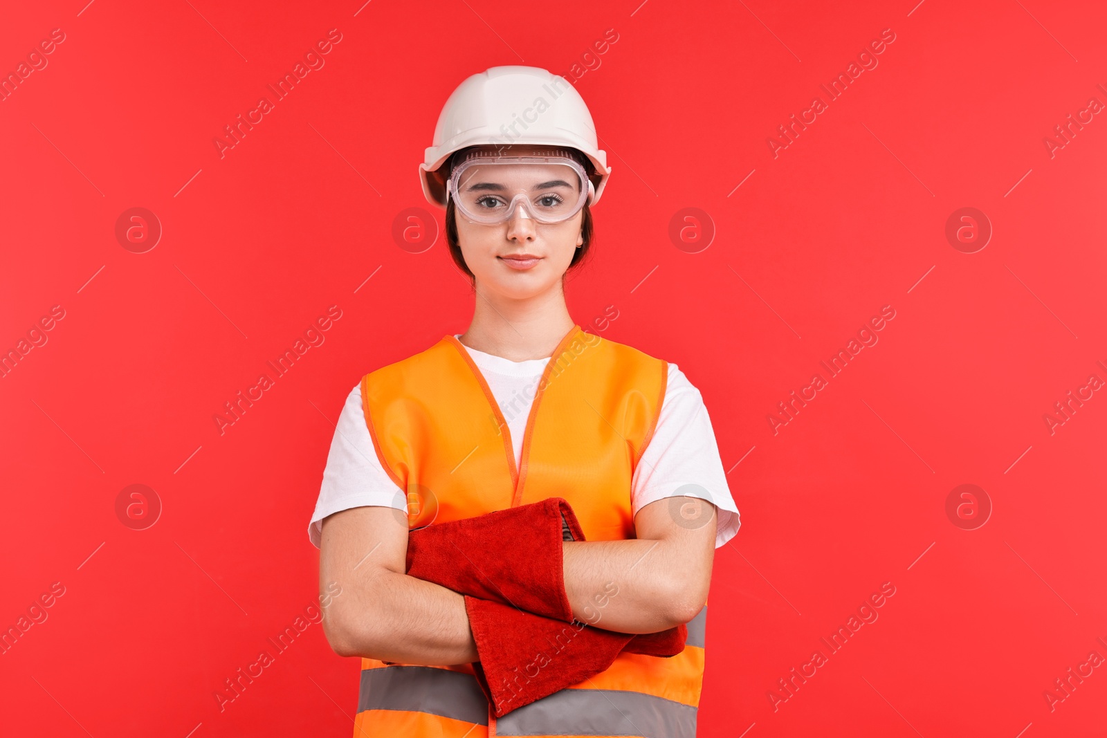 Photo of Girl with safety equipment on red background. Work for teenagers