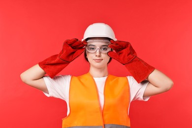 Photo of Girl with safety equipment on red background. Work for teenagers