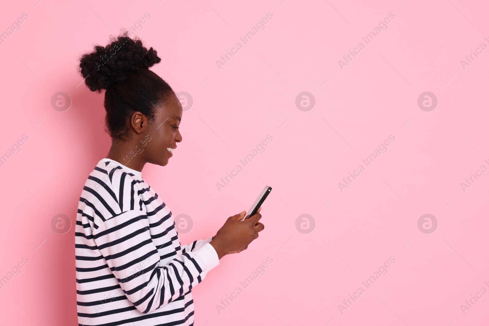 Photo of Happy woman with smartphone on pink background. Space for text