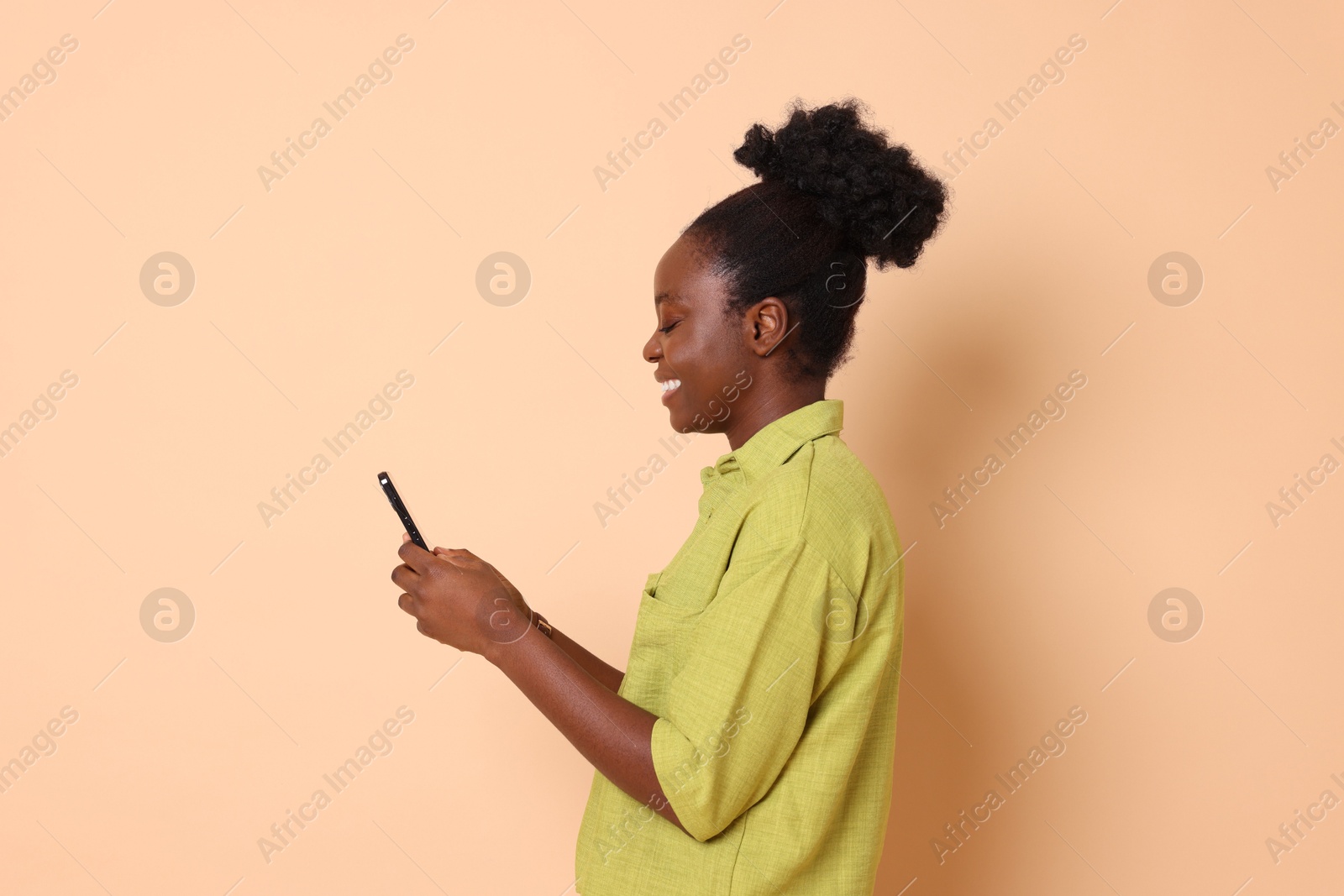 Photo of Happy woman with smartphone on beige background. Space for text