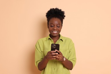 Photo of Happy woman with smartphone on beige background