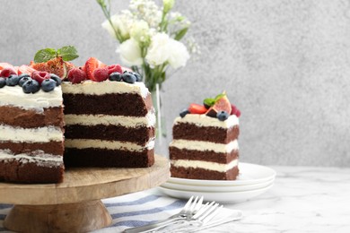 Photo of Piece of delicious chocolate sponge cake with berries served on white table