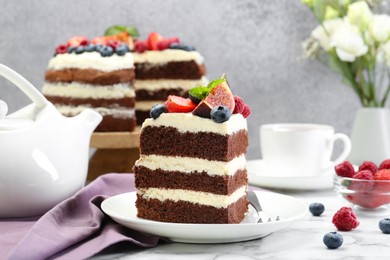 Photo of Piece of delicious chocolate sponge cake with berries served on white table