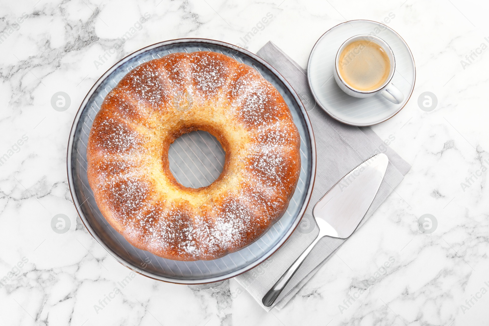 Photo of Freshly baked sponge cake, server and coffee on white marble table, top view