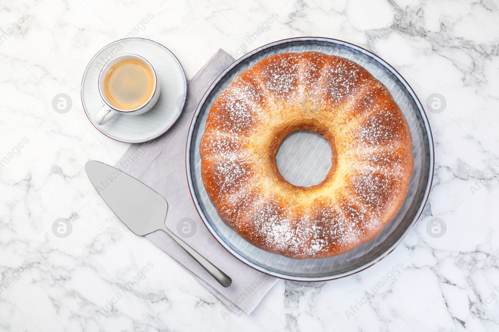 Photo of Freshly baked sponge cake, server and coffee on white marble table, top view