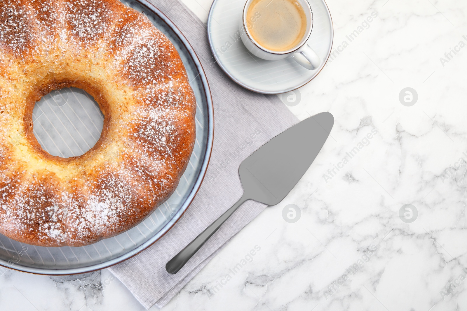 Photo of Freshly baked sponge cake, server and coffee on white marble table, top view