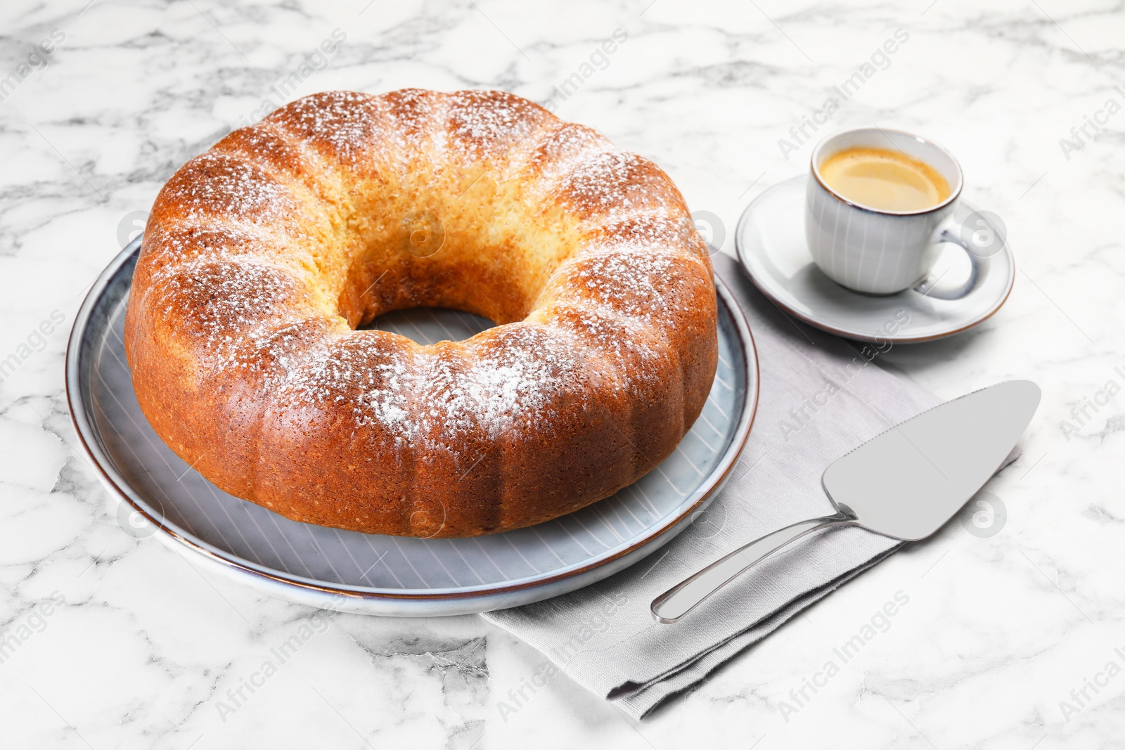 Photo of Freshly baked sponge cake, server and coffee on white marble table