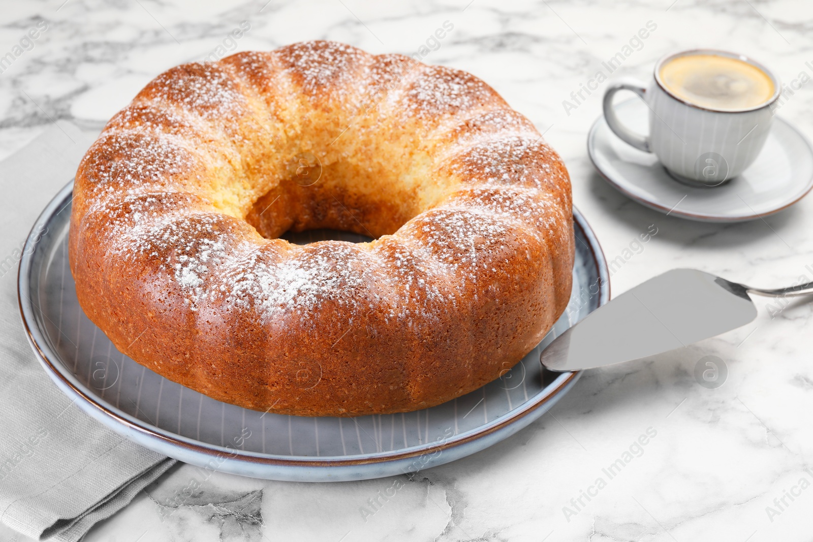 Photo of Freshly baked sponge cake, server and coffee on white marble table, closeup