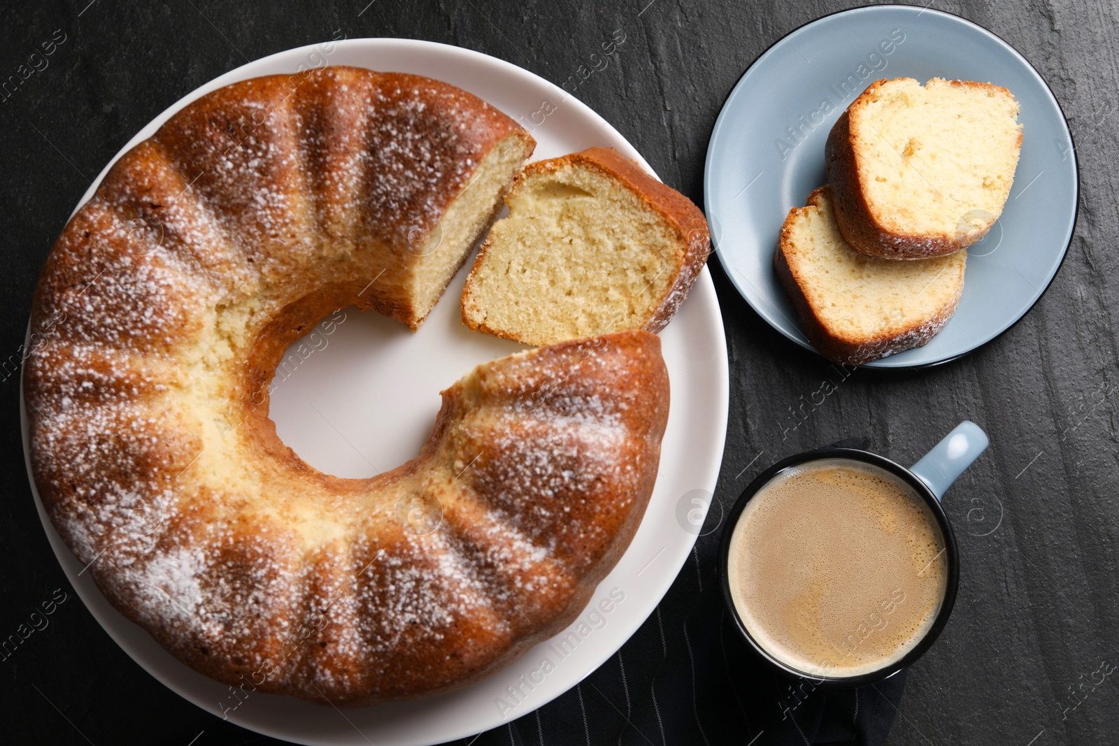 Photo of Freshly baked sponge cake and coffee on black table, top view