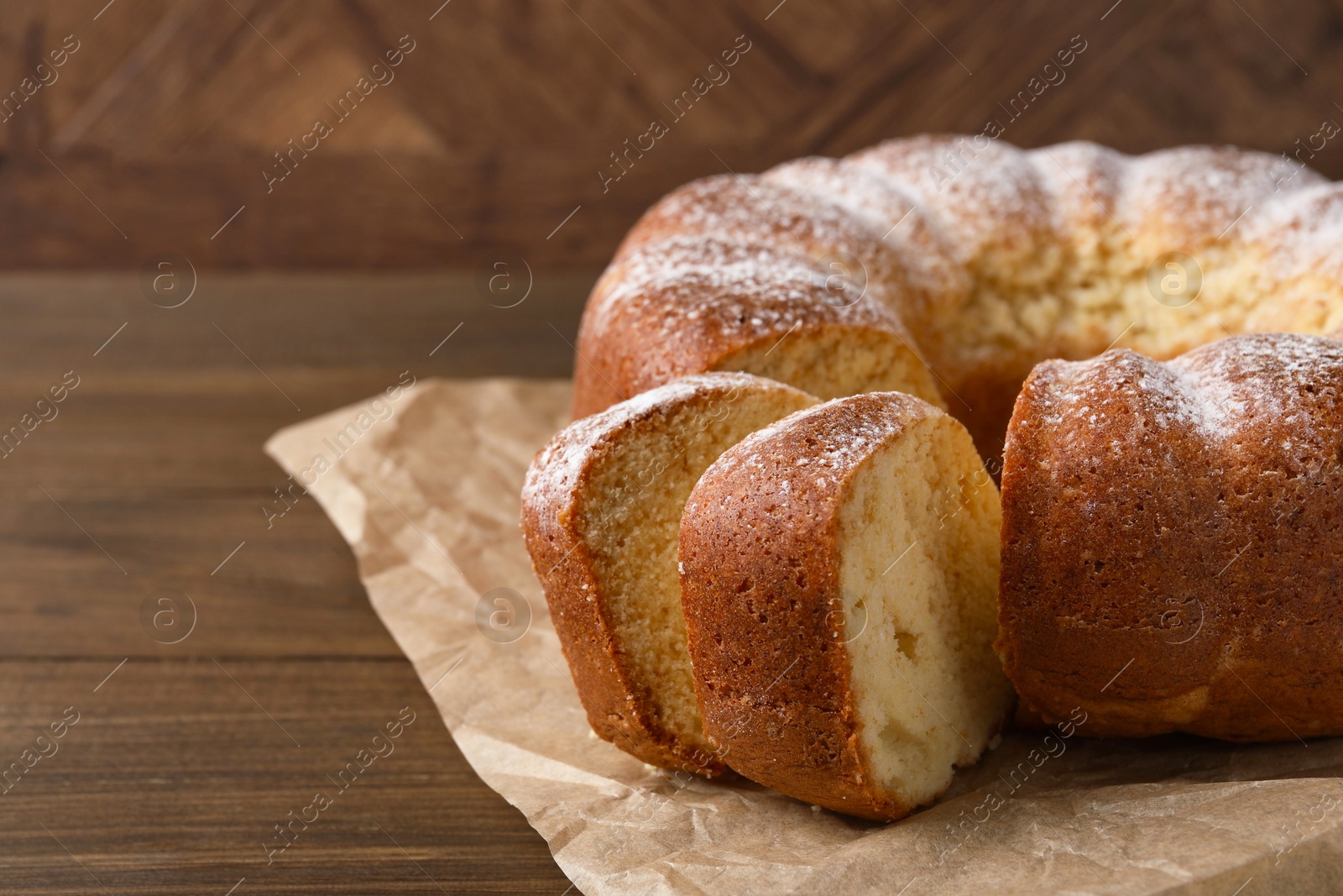 Photo of Freshly baked sponge cake on wooden table, closeup