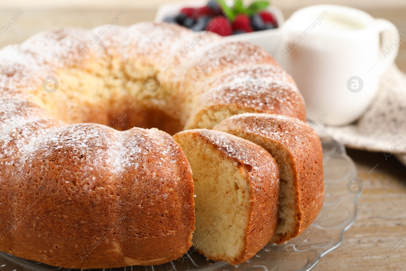 Photo of Freshly baked sponge cake and milk on wooden table, closeup