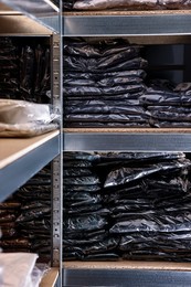 Photo of Many different types of fabric on shelves in professional atelier