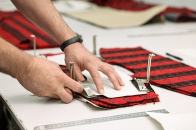 Photo of Man working at white table in professional workshop, closeup