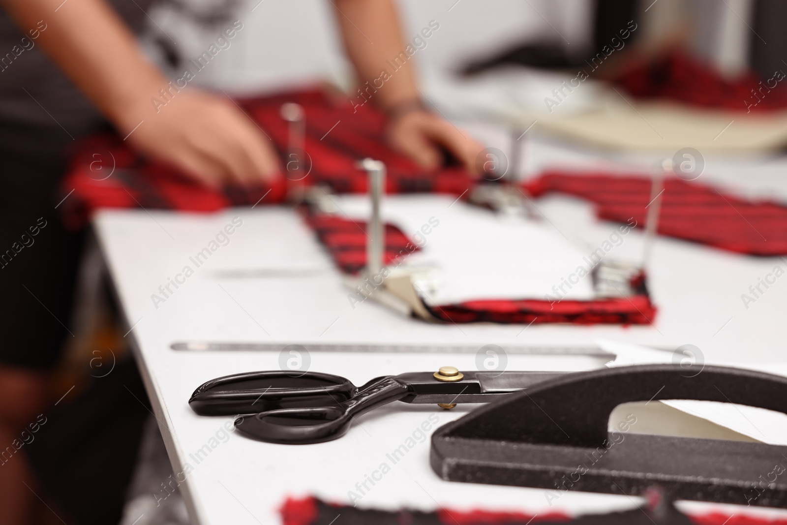 Photo of Man working at white table in professional workshop, closeup