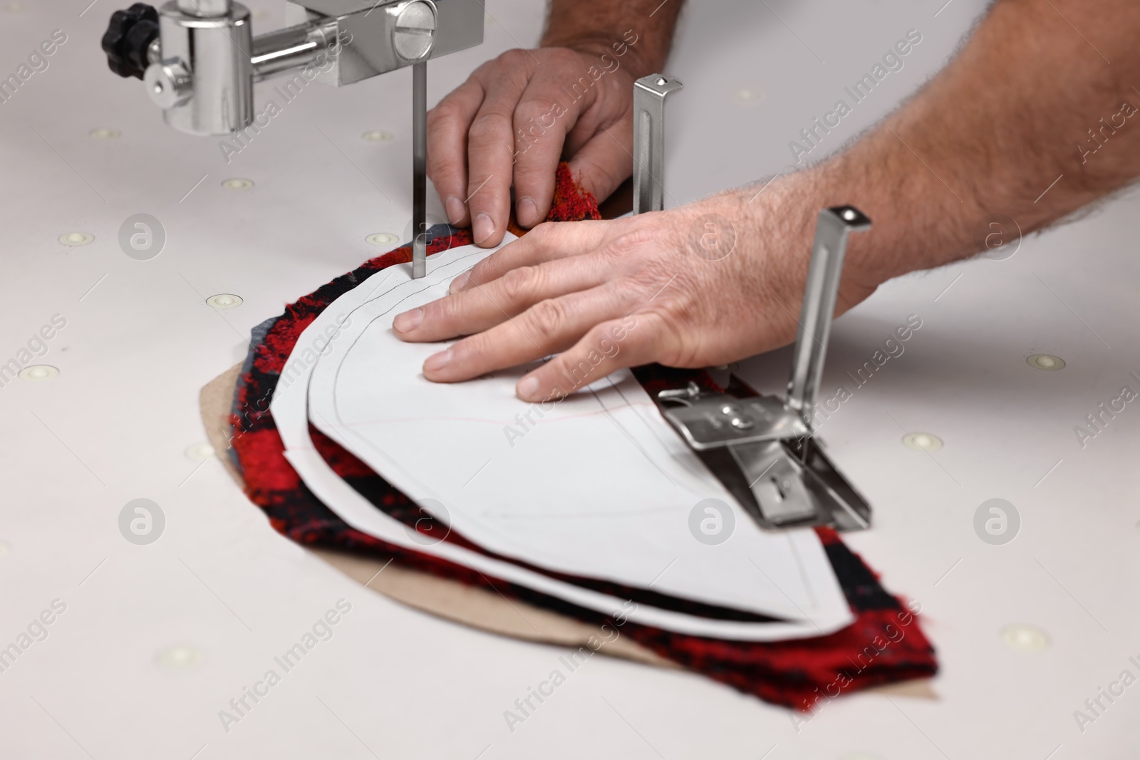 Photo of Man working at white table in professional workshop, closeup