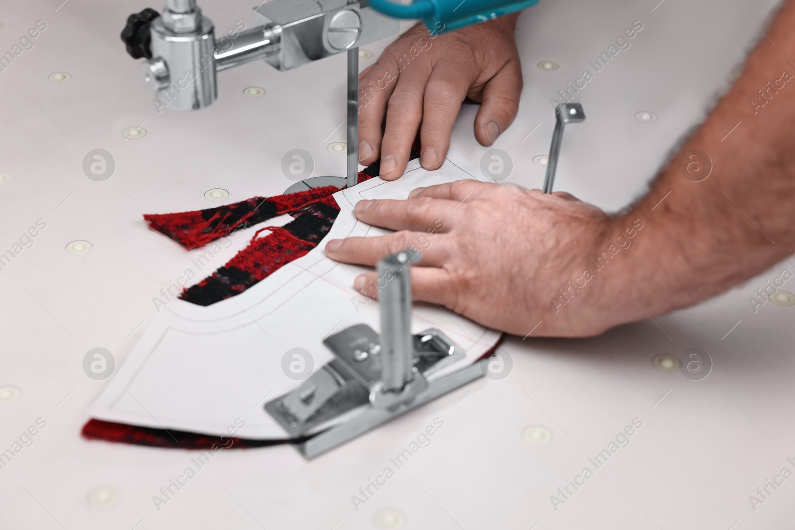 Photo of Man working at white table in professional workshop, closeup