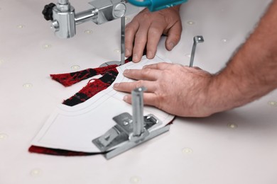 Photo of Man working at white table in professional workshop, closeup