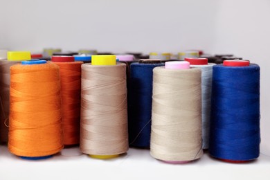 Photo of Many different spools of thread on white shelf in professional workshop