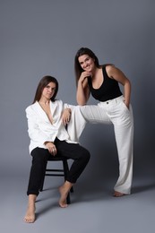 Photo of Portrait of beautiful twin sisters on grey background