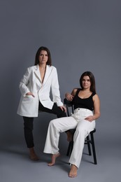 Photo of Portrait of beautiful twin sisters on grey background