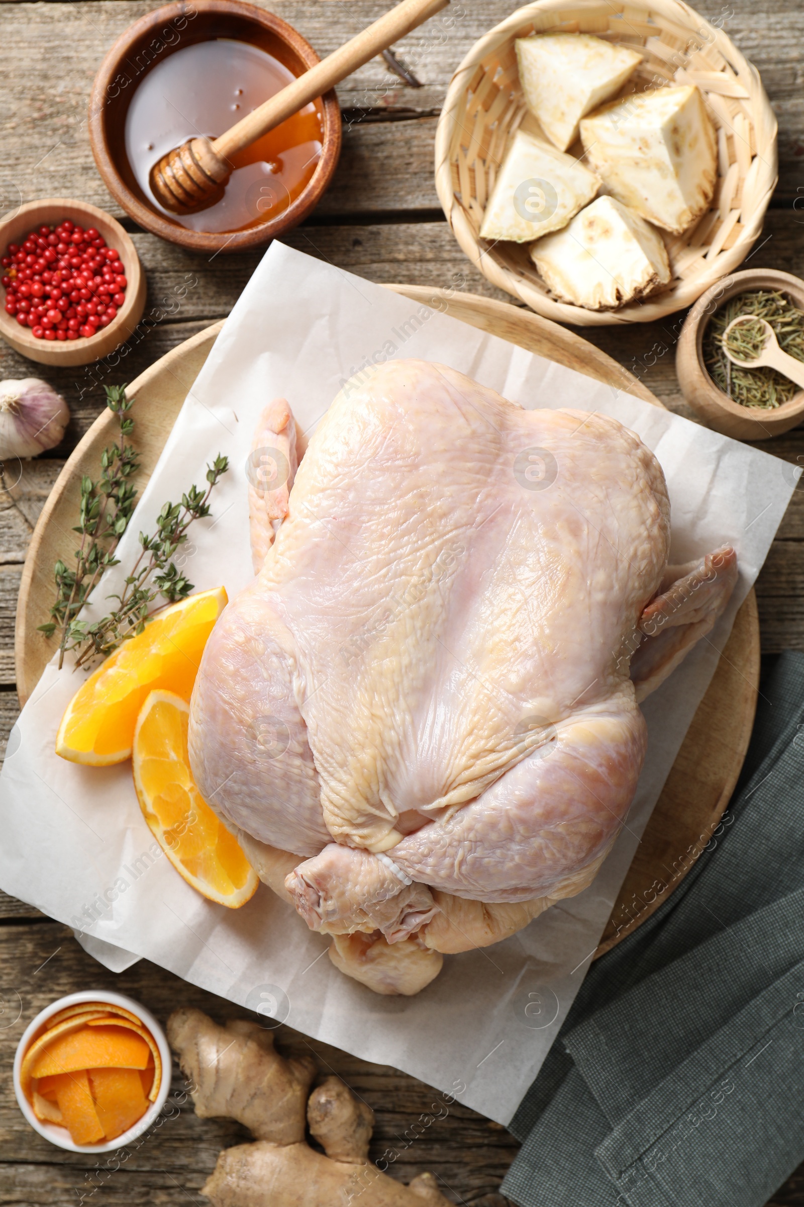 Photo of Uncooked turkey, orange slices and spices on wooden table, flat lay