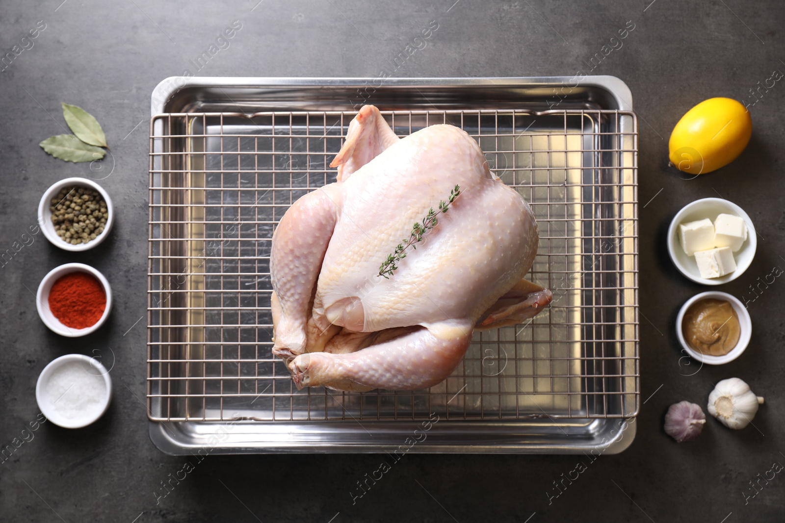 Photo of Raw turkey and spices on grey table, flat lay