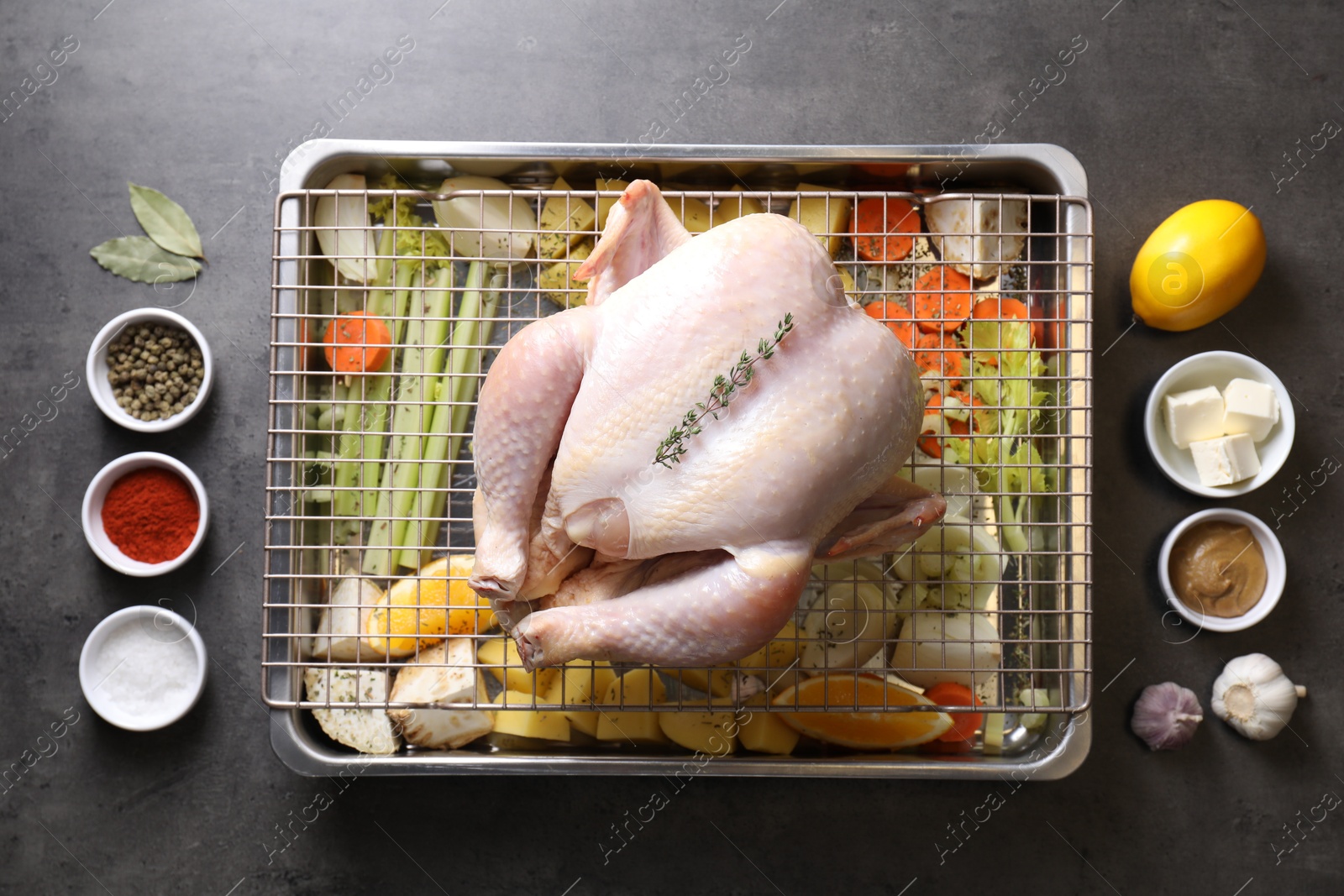 Photo of Raw turkey with different vegetables and spices on grey table, flat lay