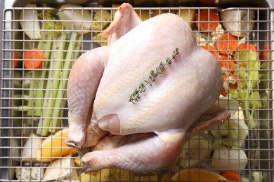 Photo of Raw turkey and vegetables in baking dish, top view