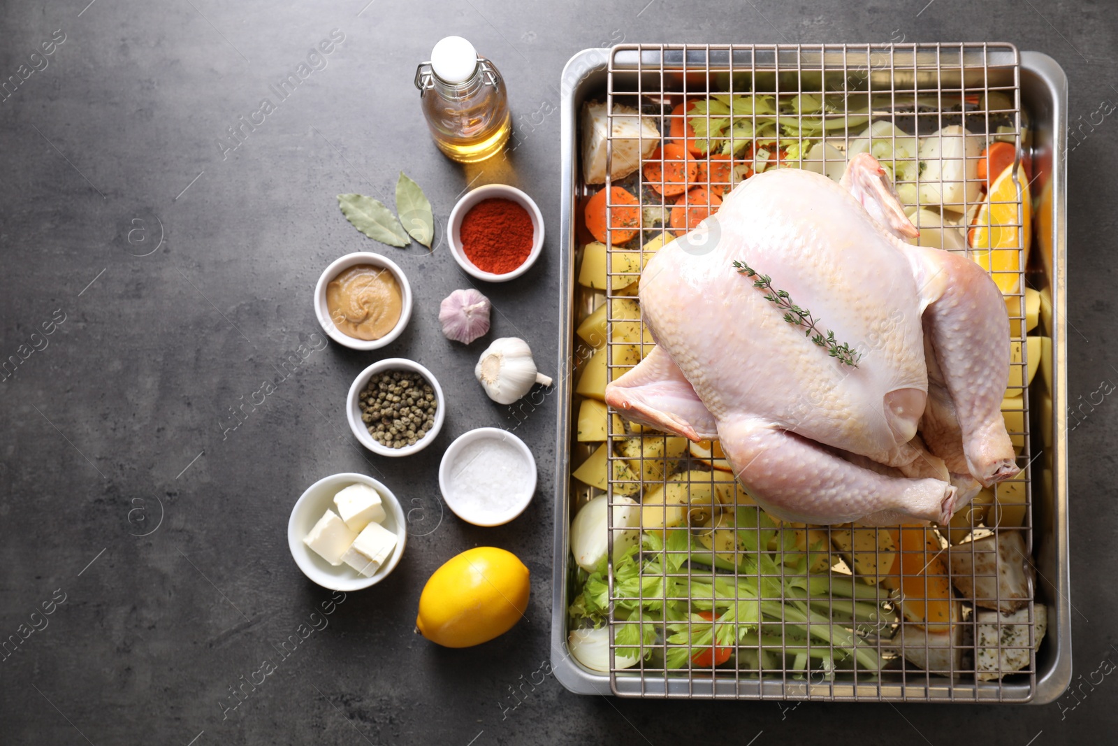 Photo of Raw turkey with different vegetables and spices on grey table, flat lay. Space for text